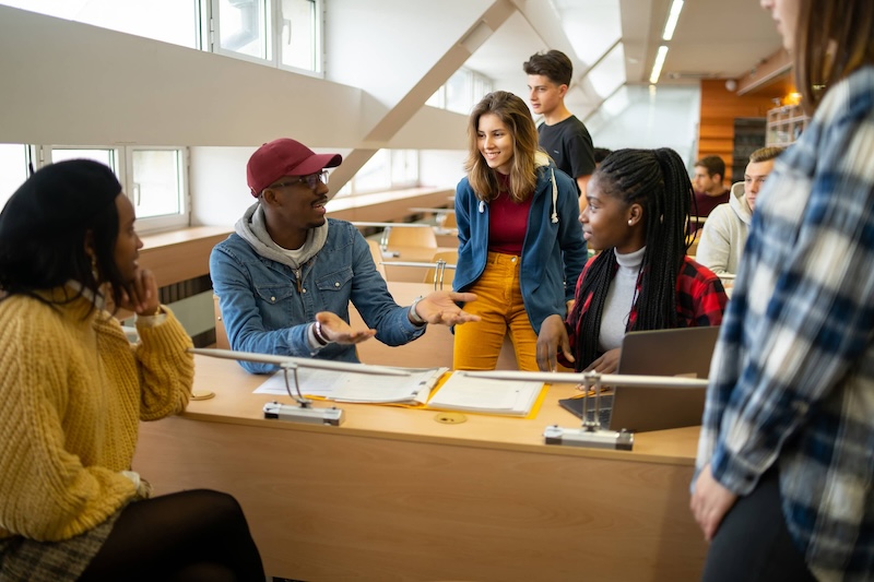 Image of students together with a laptop and notebooks