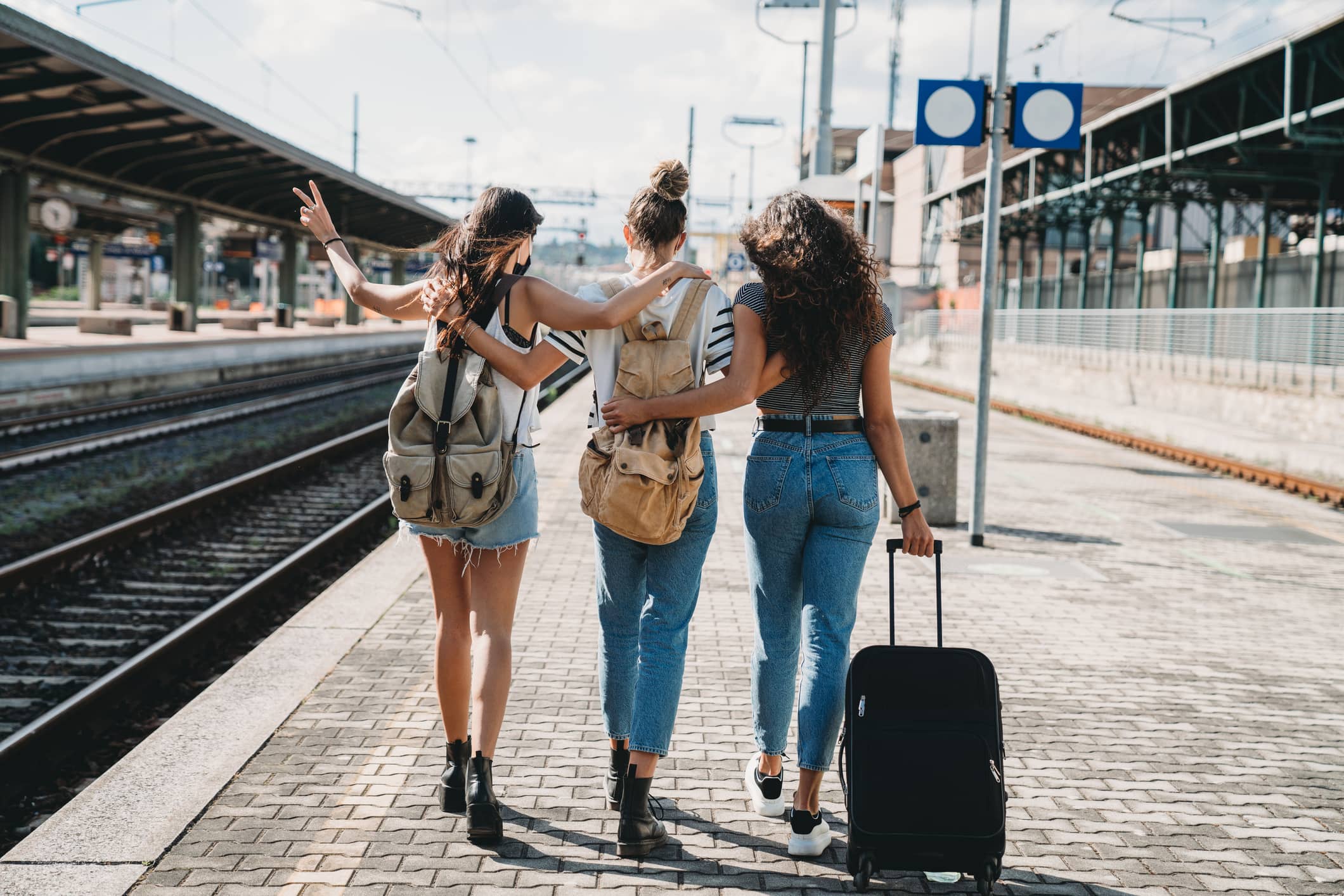 Image of three people traveling together at a train station