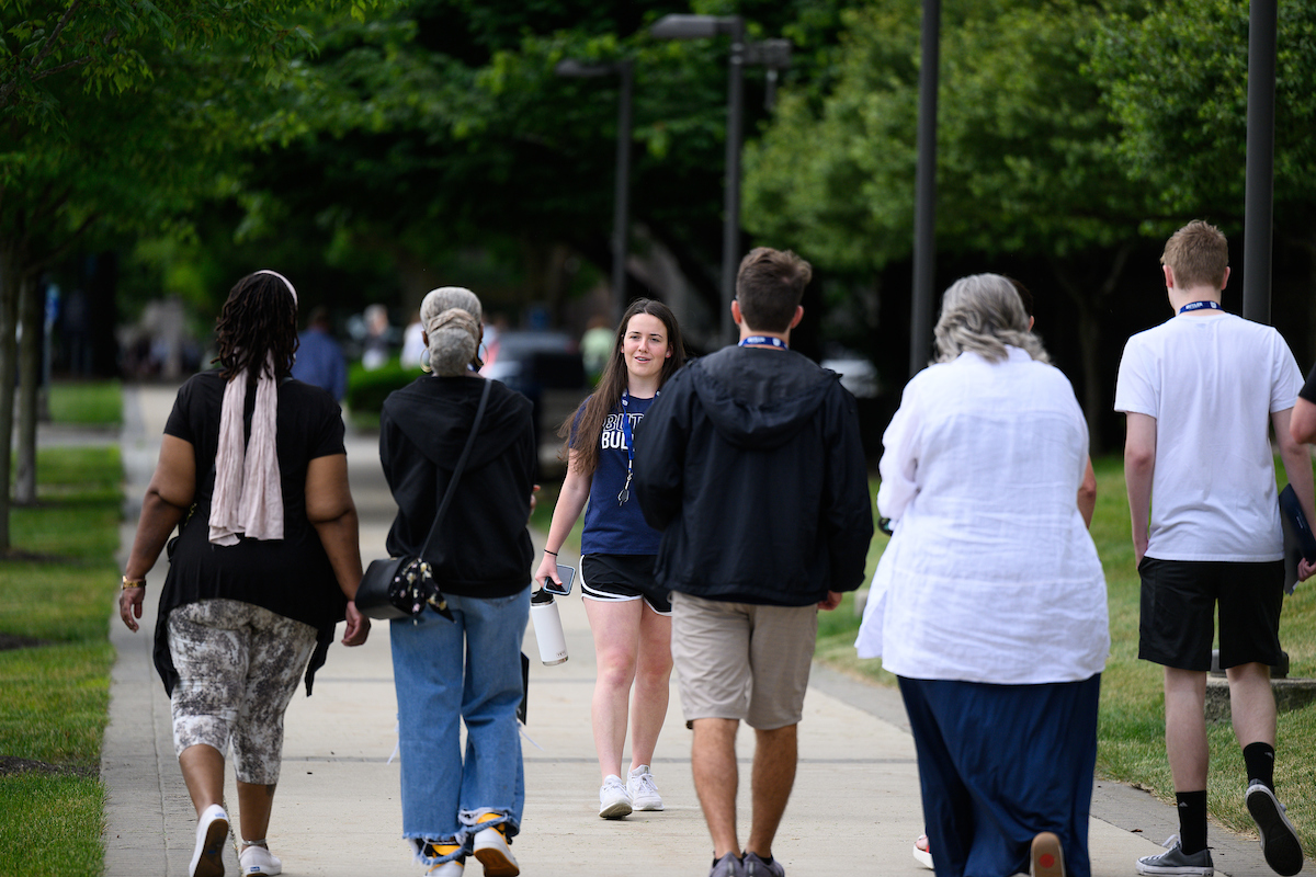A tour guide leads a family on a campus tour.