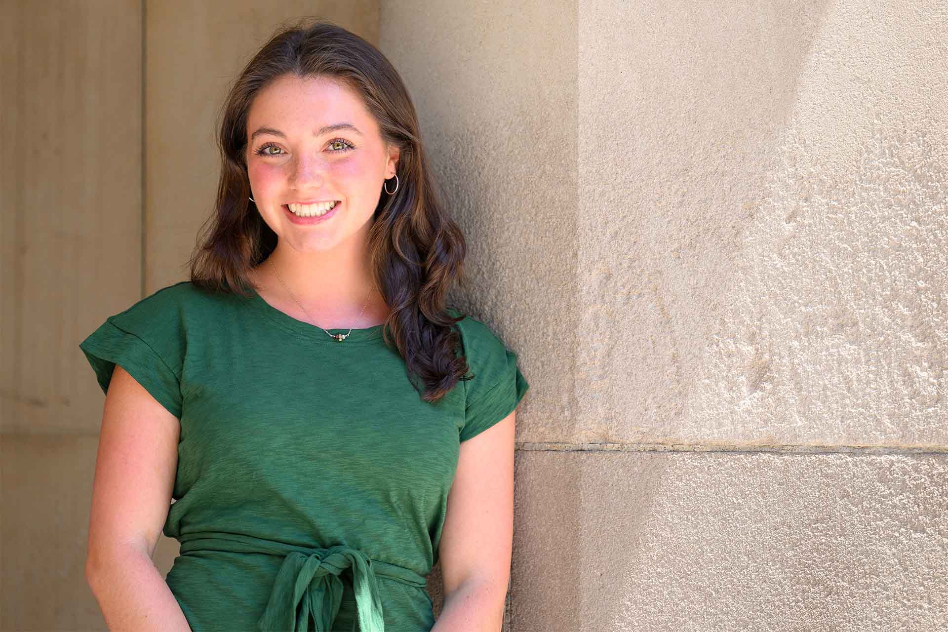 Portrait of Admission Counselor Caroline Modelski leaning on a limestone wall.